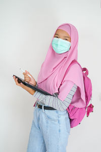 Midsection of woman holding umbrella against white background