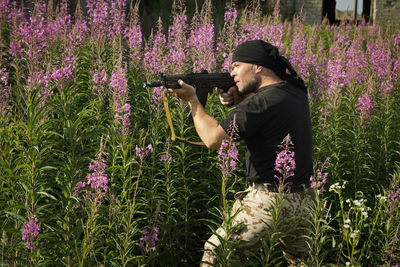 Full length of person holding purple flowering plants