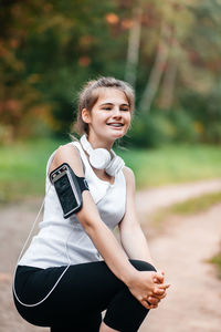 Smiling teenager girl standing at park