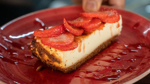 A close up image of a tasty piece of homemade strawberry cheesecake dessert