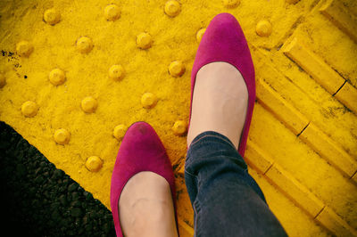 Low section of woman standing on footpath