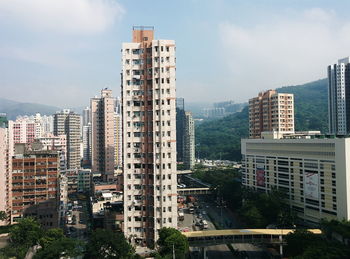 Residential buildings by street against sky