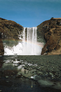 Scenic view of waterfall against sky