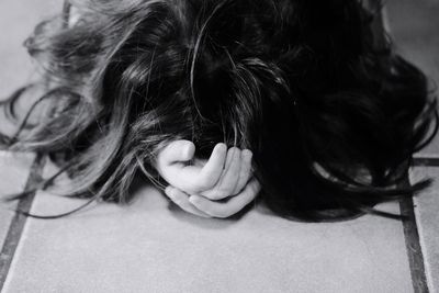 Close-up of girl with black hair lying on floor