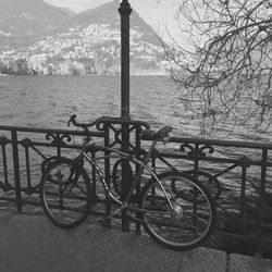 Bicycle by water against sky