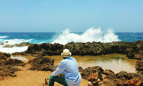 Rear view of woman looking at sea against sky