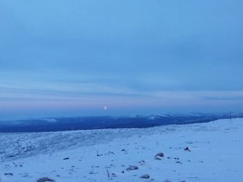 Scenic view of snow covered landscape against blue sky