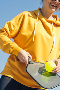 Midsection of man holding headphones