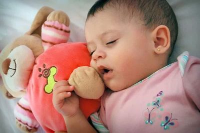 Baby girl sleeping on bed at home