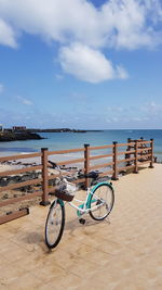 Bicycle on beach against sky