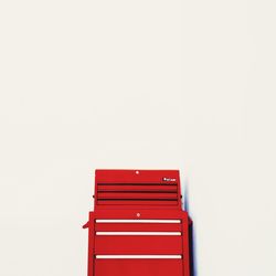 Close-up of red wooden table against white background