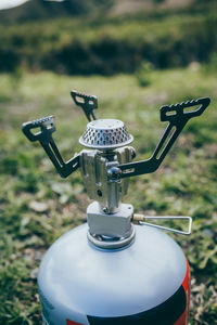 Close-up of faucet and bicycle on field