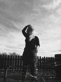 Rear view of woman standing against sky looking into the distance