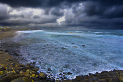 Scenic view of sea against storm clouds