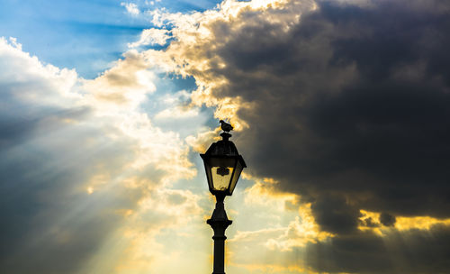 High section of lamp post against cloudy sky