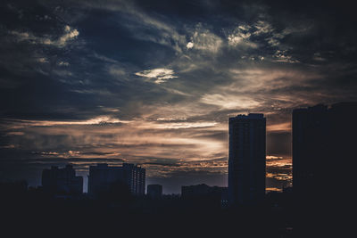 Skyscrapers in city at sunset