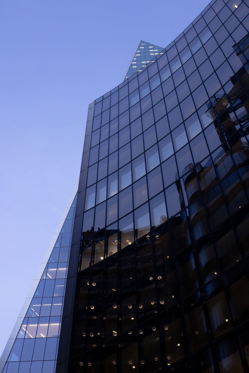 LOW ANGLE VIEW OF GLASS BUILDING AGAINST CLEAR SKY