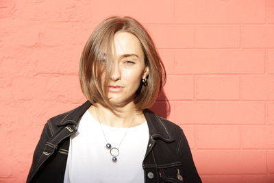 Portrait of beautiful woman standing against wall