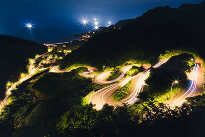 High angle view of illuminated city against sky at night