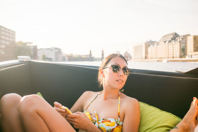 Portrait of a young woman looking at city