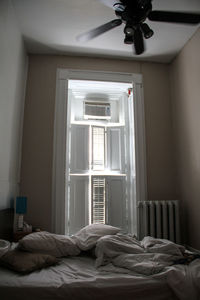 Man relaxing on bed by window at home