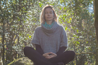 Portrait of a smiling young woman against trees