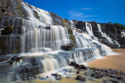 Low angle view of waterfall against sky