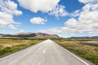 Road amidst green landscape against sky