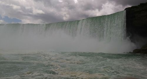 Scenic view of waterfall against sky