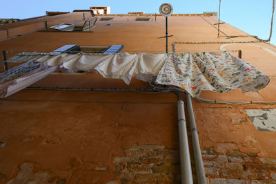 Low angle view of clothes drying against building