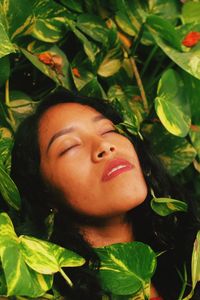 Close-up portrait of a smiling young woman with leaves