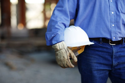 Close up of a male construction foreman worker holding a hard ha