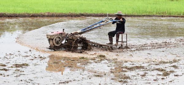 Male farmer farming with machinery at farm