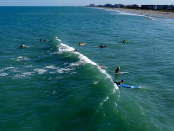 High angle view of people surfboarding in sea