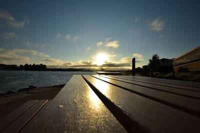 Surface level of lake against sky during sunset