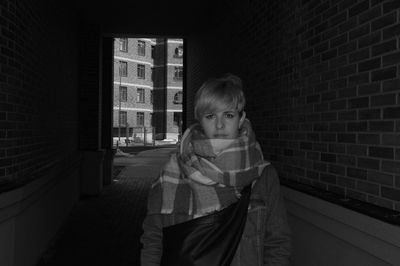 Portrait of girl standing against wall