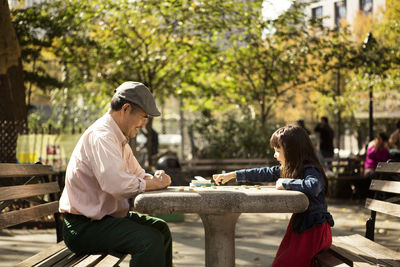 Side view of woman sitting on railing