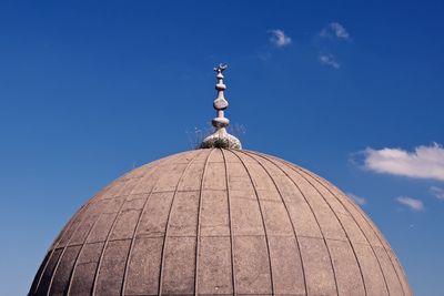 Weathered mosque dome against sky