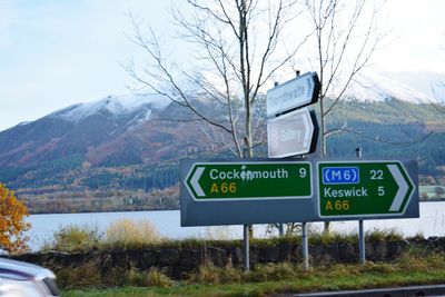 Information sign on road against sky