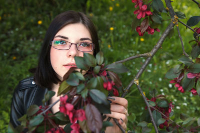 Portrait of young woman with red flowers