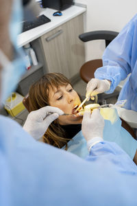 Dentists treating woman at clinic