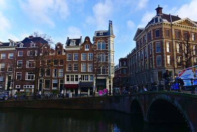 Bridge over river against buildings in city