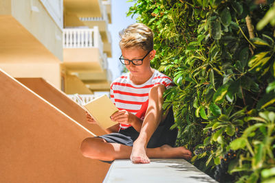 Full length of boy sitting on staircase