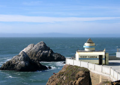 Rock formation by sea against sky