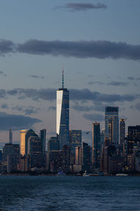 Lower manhattan skyline at sunset viewed from the water.