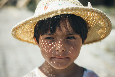 Portrait of small girl in straw hat on a sunny day