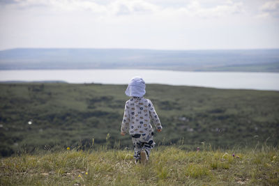 Rear view of woman walking on field