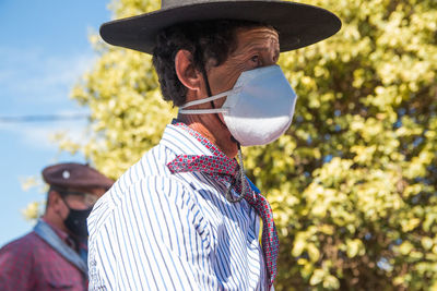 Side portrait of south american man wearing traditional clothing and face mask