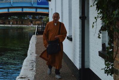 Portrait of man with umbrella walking in water