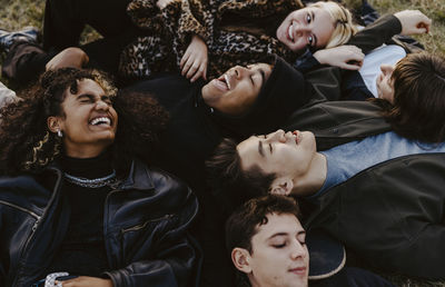 High angle view of male and female friends lying down during sunset